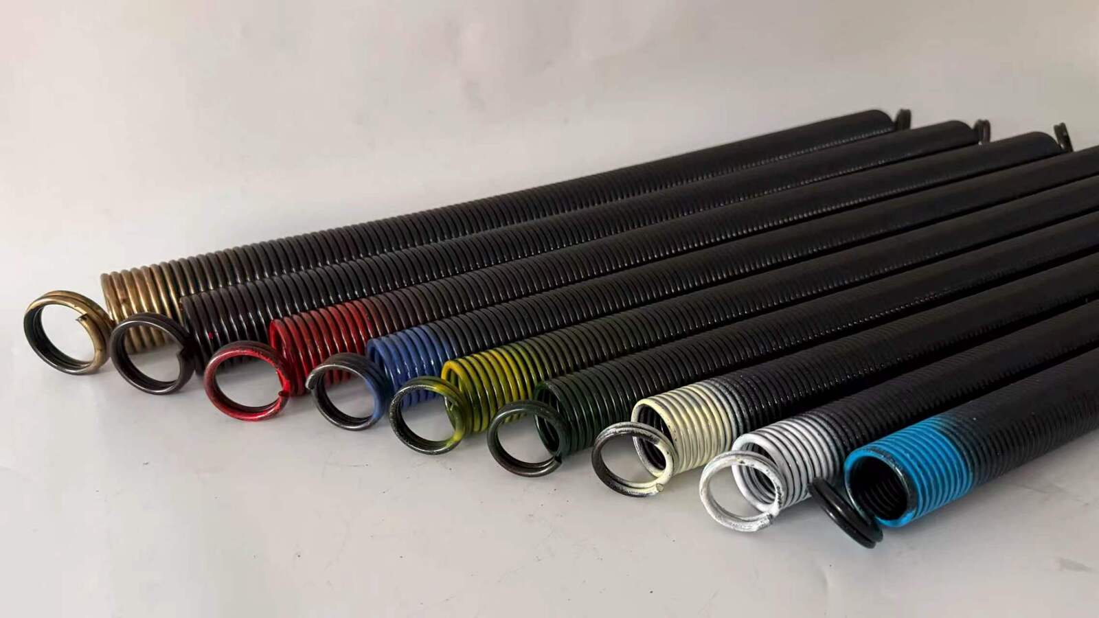 Color-coded garage door extension springs in multiple finishes